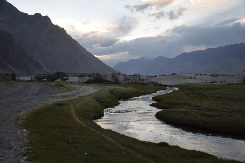 Hunder Sand dunes with green meadows ,river and beautiful mountains after sunset